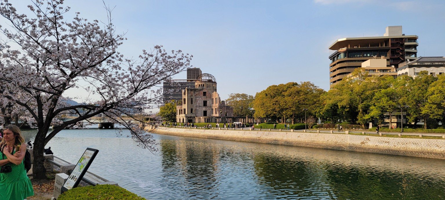 Atomic Bomb Dome across the river in Hiroshima with cherry blossoms