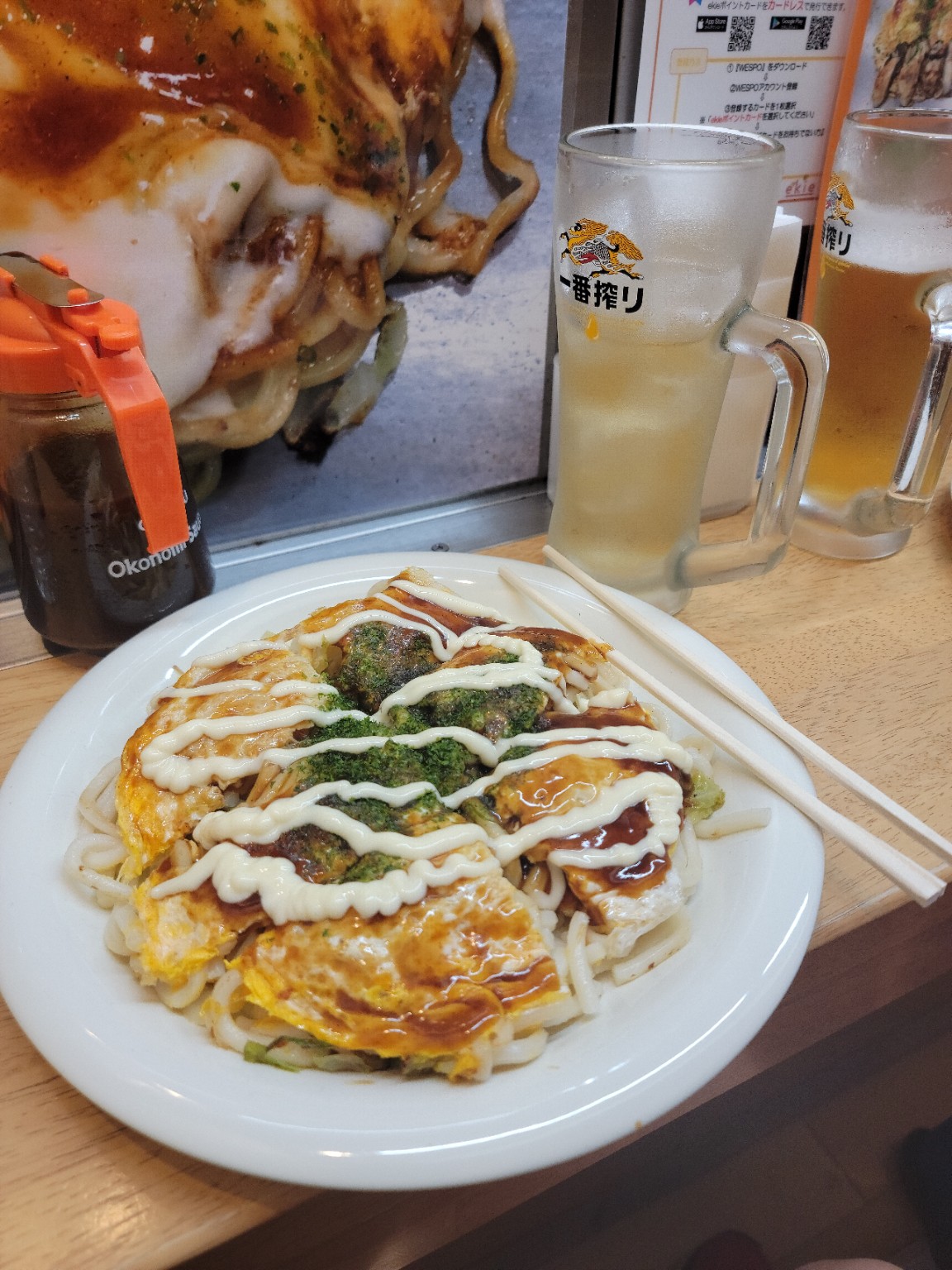 Tammy’s Hiroshima-style okonomiyaki topped with sauce and mayonnaise at a small station restaurant