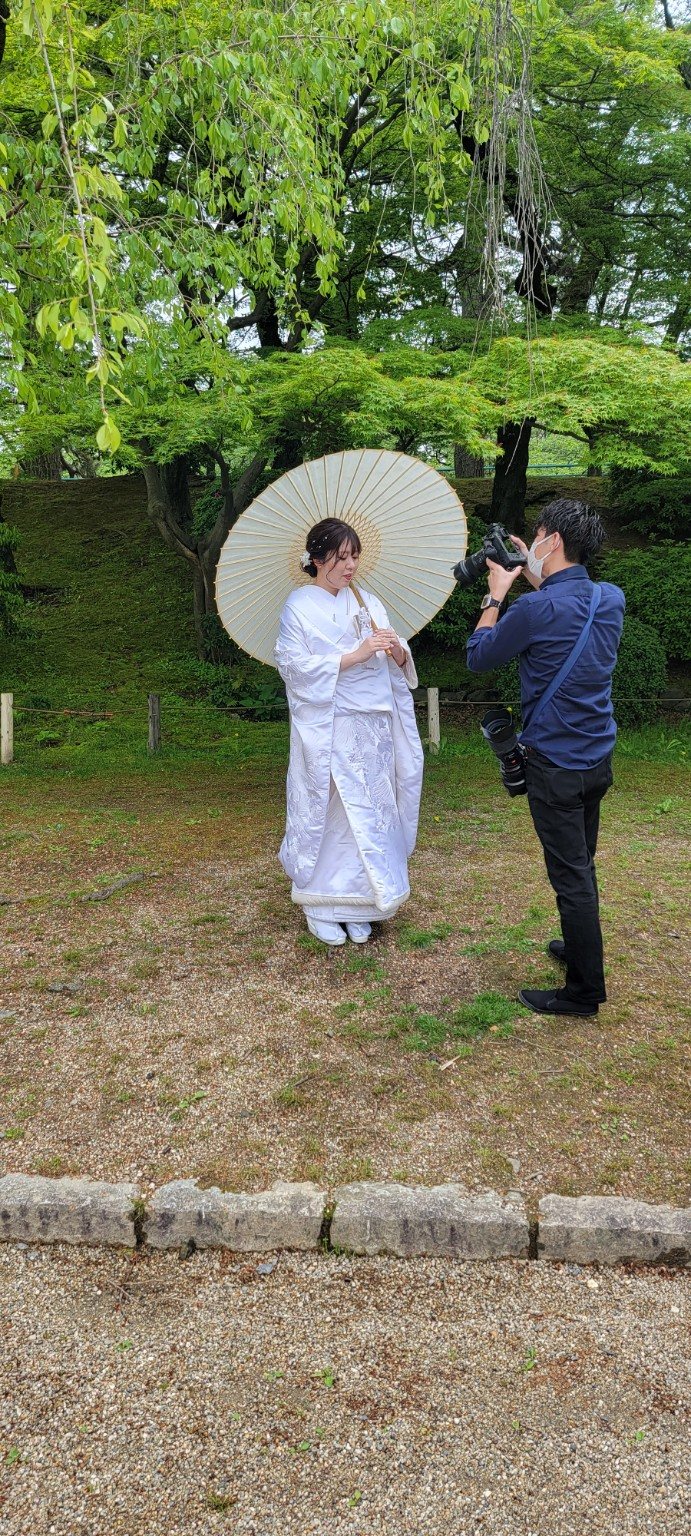 A traditional Japanese wedding portrait being photographed in a garden